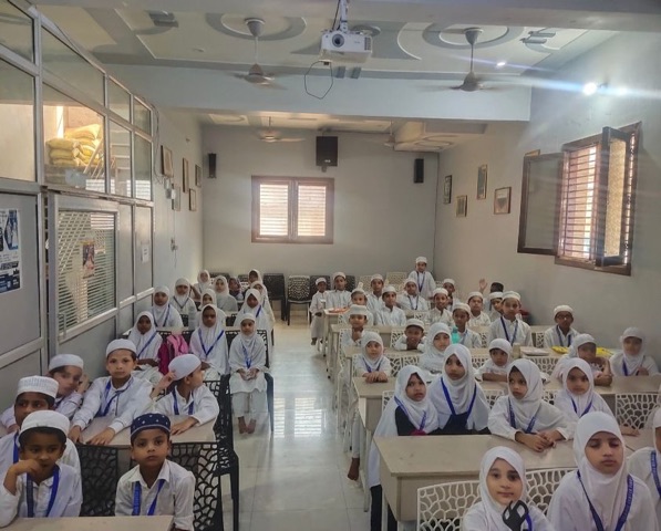 Children in white uniforms seated in an Islamic Children Academy classroom