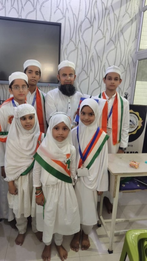 Young students wearing tricolour sashes with their teacher on Independence Day
