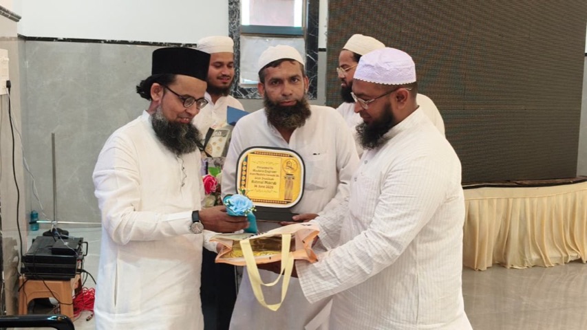 A teacher of Rahmat Maktab being honoured with a memento